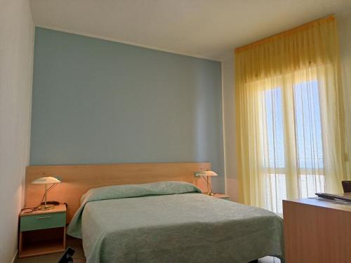 a bedroom with a bed and a window at Hotel Ariston Imperial in Porto Garibaldi