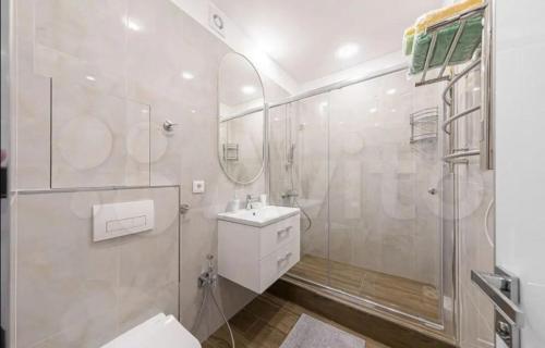 baño blanco con ducha y lavamanos en VIP apart 257 en Tiflis