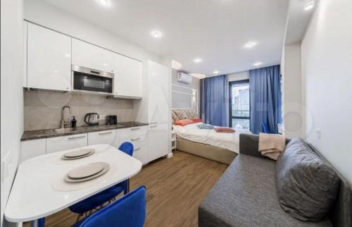 eine Küche und ein Wohnzimmer mit einem Tisch und einem Bett in der Unterkunft VIP apart 257 in Tbilisi City