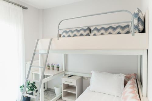 a bedroom with a bunk bed with a ladder at Onar Village Luxury Apartments in Kavala