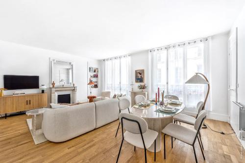 un salon avec un canapé, une table et des chaises dans l'établissement Marais - Montmorency 2bdr by B'Your Home, à Paris