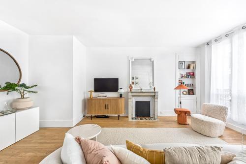 un salon avec un canapé et une cheminée dans l'établissement Marais - Montmorency 2bdr by B'Your Home, à Paris