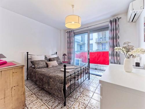une chambre avec un lit et une grande fenêtre dans l'établissement Superbe Appartement Près de la Gare-Clim-Wifi-Espace dedié au Travail, à Nice