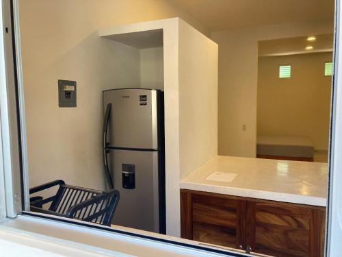 a kitchen with a stainless steel refrigerator and a counter at Apartamentos mondala in Brisas de Zicatela