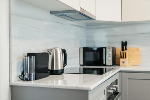a kitchen counter with two coffees and two microwaves at Onar Village Luxury Apartments in Kavala