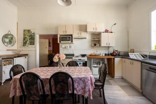 a kitchen with a table and chairs and a kitchen with a table and a kitchen at Brunnerton Lodge and Backpackers in Greymouth