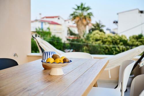 a bowl of fruit sitting on a wooden table at Skiathos Icon- Apartment 3 by Mojo Stays in Skiathos