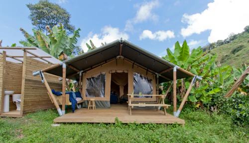 a tent with a wooden deck in the grass at Glamping Jardín in Jardin