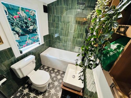 ein Badezimmer mit einem weißen WC und einer grün gefliesten Wand in der Unterkunft Park Mount Residences - Boutique 1 Bedroom Apartment In Leeds With Free Parking in Kirkstall