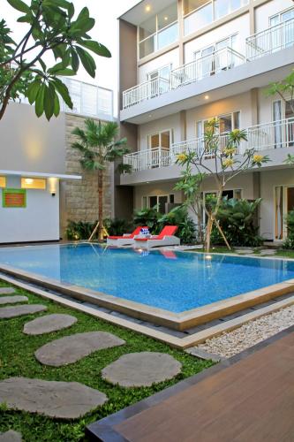 a swimming pool in front of a building at Choice Stay Hotel Denpasar in Denpasar