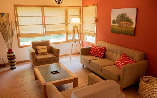 uma sala de estar com um sofá e uma mesa em Casa en La Cascada em San Martín de los Andes