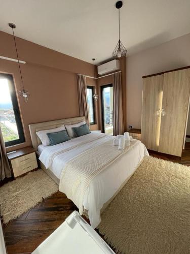 a large bedroom with a large bed and a large window at Vila Isi in Korçë