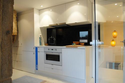 a kitchen with a white stove and a microwave at Blue Home in Santiago de Compostela