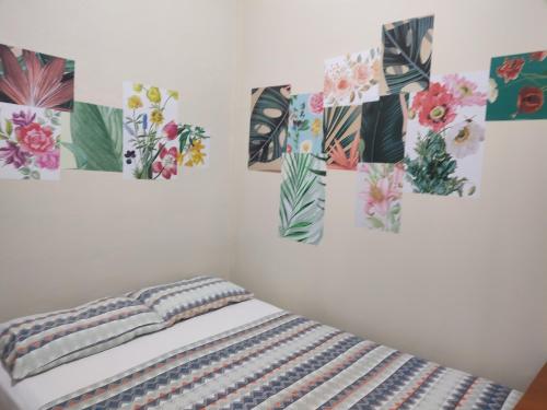 a bedroom with four paintings on the wall at Ti Hostel Trindade Hospeda in Trindade