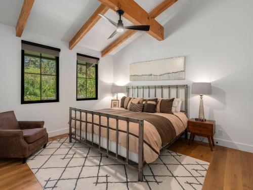 a bedroom with a bed and a couch and windows at Modern Millcreek Home in Incline Village