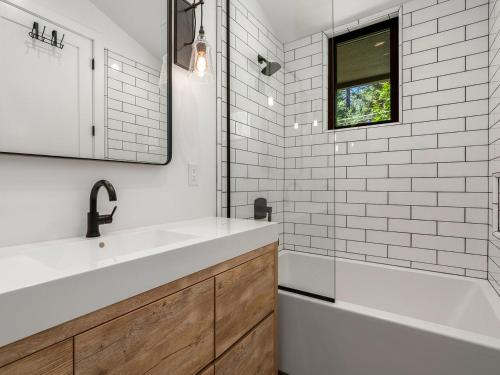 a bathroom with a sink and a tub and a mirror at Modern Millcreek Home in Incline Village