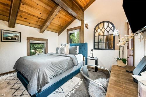 um quarto com uma cama azul num quarto com tectos em madeira em 1331 Zurich Lane - Modern Mountain Chalet em Incline Village