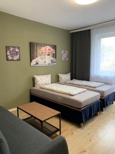 two beds in a room with a couch and a table at Enjoy Berlin in Berlin