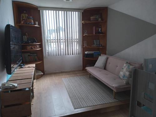 a living room with a couch and a tv at Depa Cholulita in Cholula