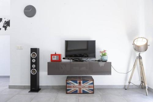 een kamer met een televisie en een tafel met een luidspreker bij Casa Turquesa, shared pool in Puerto del Carmen