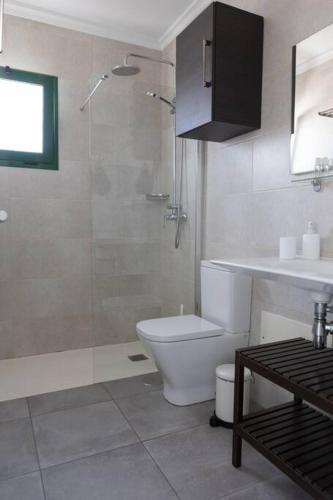 a bathroom with a shower and a toilet and a sink at Casa Turquesa, shared pool in Puerto del Carmen