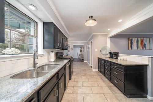 uma grande cozinha com armários pretos e um lavatório em Colleens Corner Captivating 4bed 2.5 bath in Charming Neighborhood em Little Rock