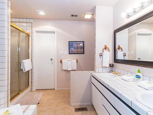 une salle de bain blanche avec deux lavabos et un miroir dans l'établissement Mountain Shadows #172 - - pool, à Incline Village