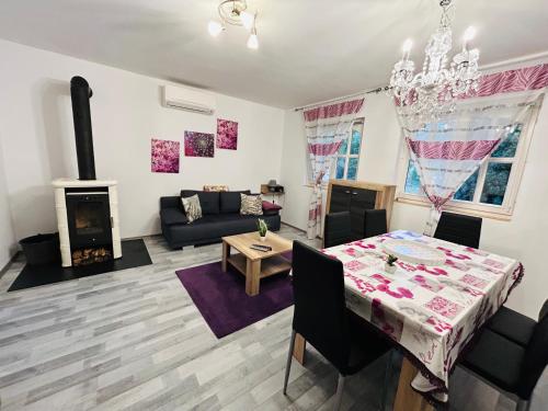 sala de estar con mesa y sala de estar con chimenea en Idyllisches Ferienhaus en Siófok