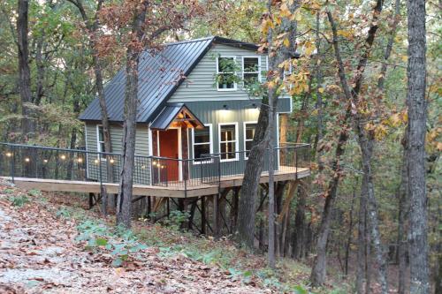 a tiny house on a deck in the woods at Secluded Treehouse in the Woods - Tree Hugger Hideaway in Branson