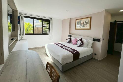 Un dormitorio con una cama y una mesa. en NEW Luxury & Modern FARE MAOTI en Arue