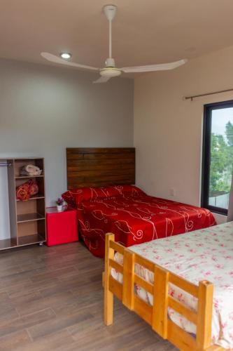 a bedroom with two beds and a red bedspread at Casa Biznaga in Oaxaca City