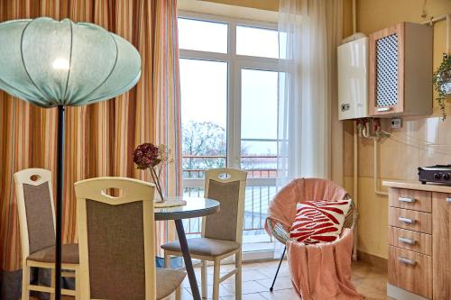 eine Küche mit einem Tisch und Stühlen sowie einem Fenster in der Unterkunft Elite Lux Apartment with balcony in Mukatschewo