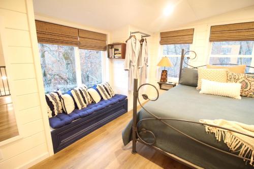 1 dormitorio con 1 cama y 2 ventanas en Secluded Treehouse in the Woods - Tree Hugger Hideaway en Branson