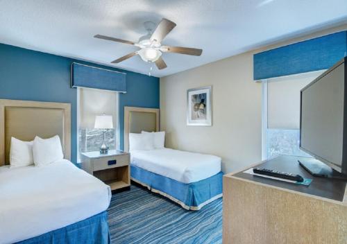 a hotel room with two beds and a flat screen tv at Summer Bay Orlando by Exploria Resorts in Orlando