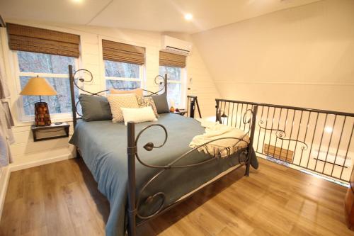 a bedroom with a bed and a balcony with windows at Secluded Treehouse in the Woods - Tree Hugger Hideaway in Branson