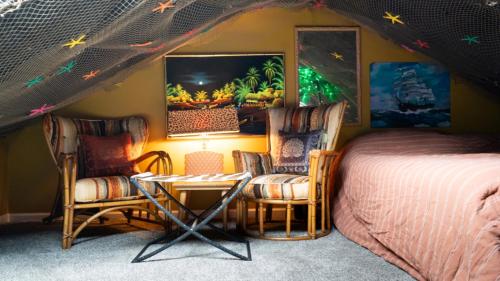 a bedroom with a bed and a table and chairs at Tropical Tiki Hut in Louisville