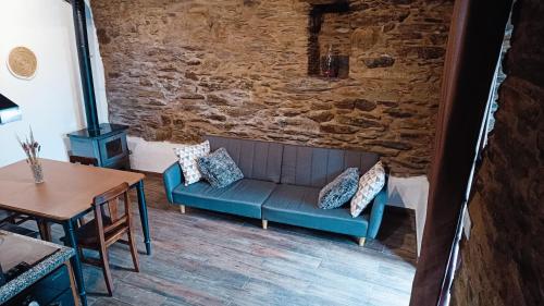 a living room with a blue couch and a table at Casa do Freire - Serra da Estrela in Aguincho