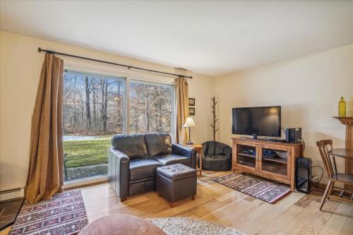 a living room with a chair and a television at Cozy One-Bedroom Edgemont Condo with Ski Access & Fireplace B3 in Killington