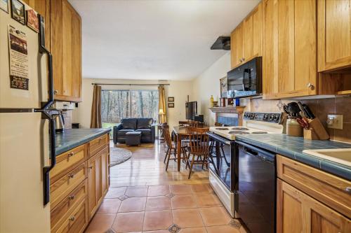 a kitchen with wooden cabinets and a counter top at Cozy One-Bedroom Edgemont Condo with Ski Access & Fireplace B3 in Killington