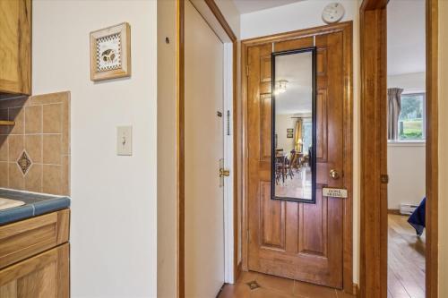 a hallway with a wooden door in a kitchen at Cozy One-Bedroom Edgemont Condo with Ski Access & Fireplace B3 in Killington