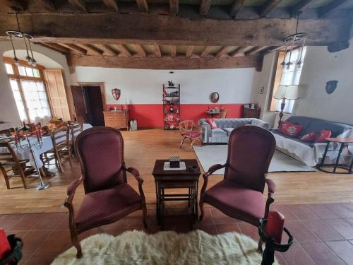 - un salon avec deux chaises et une table dans l'établissement La chatellenie Gîte de caractère de 1638., à Évaux-les-Bains