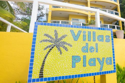 un cartel en una valla amarilla con una palmera en Del Playa Penthouse #6 Condo, en West End