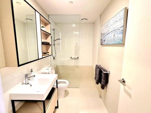 a white bathroom with a sink and a toilet at 309 Waterfront in Werribee South