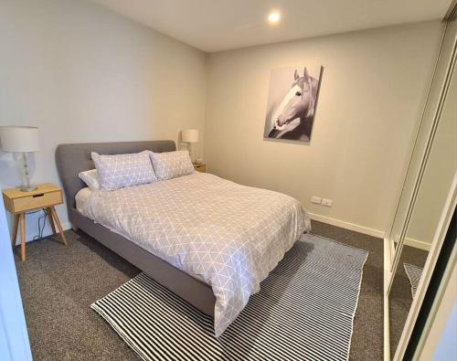 a bedroom with a bed and a picture of a horse at 309 Waterfront in Werribee South