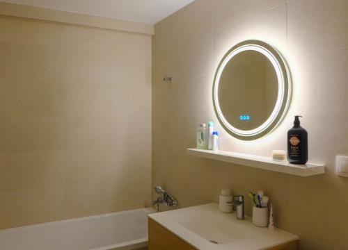 uma casa de banho com um lavatório, um espelho e uma banheira em Fox Apartment em Jáchymov
