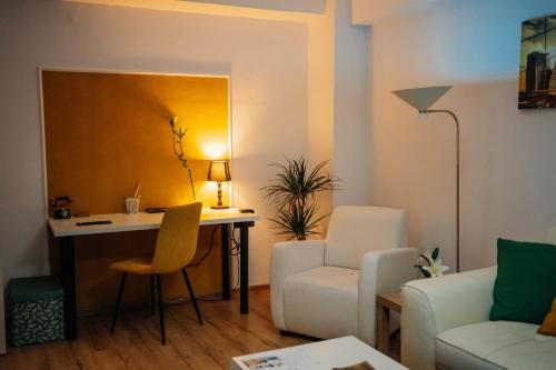 ein Wohnzimmer mit einem Schreibtisch, einem Stuhl und einem Sofa in der Unterkunft Union Experience - City Center in Timişoara