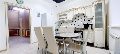 a dining room with a table and white chairs at Жк Нурсая 2комн.апартаменты in Atyrau
