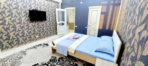 a bedroom with a bed and a tv on a wall at Жк Нурсая 2комн.апартаменты in Atyrau