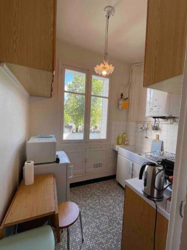 une petite cuisine avec une table et une fenêtre dans l'établissement Appartment Close to Monuments, à Paris