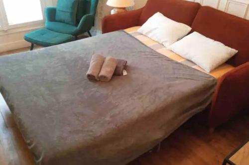 - un lit avec 2 serviettes assises au-dessus dans l'établissement Appartment Close to Monuments, à Paris